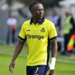 Mohammed Fuseini van Union op de rand van het veld in een geel shirt.