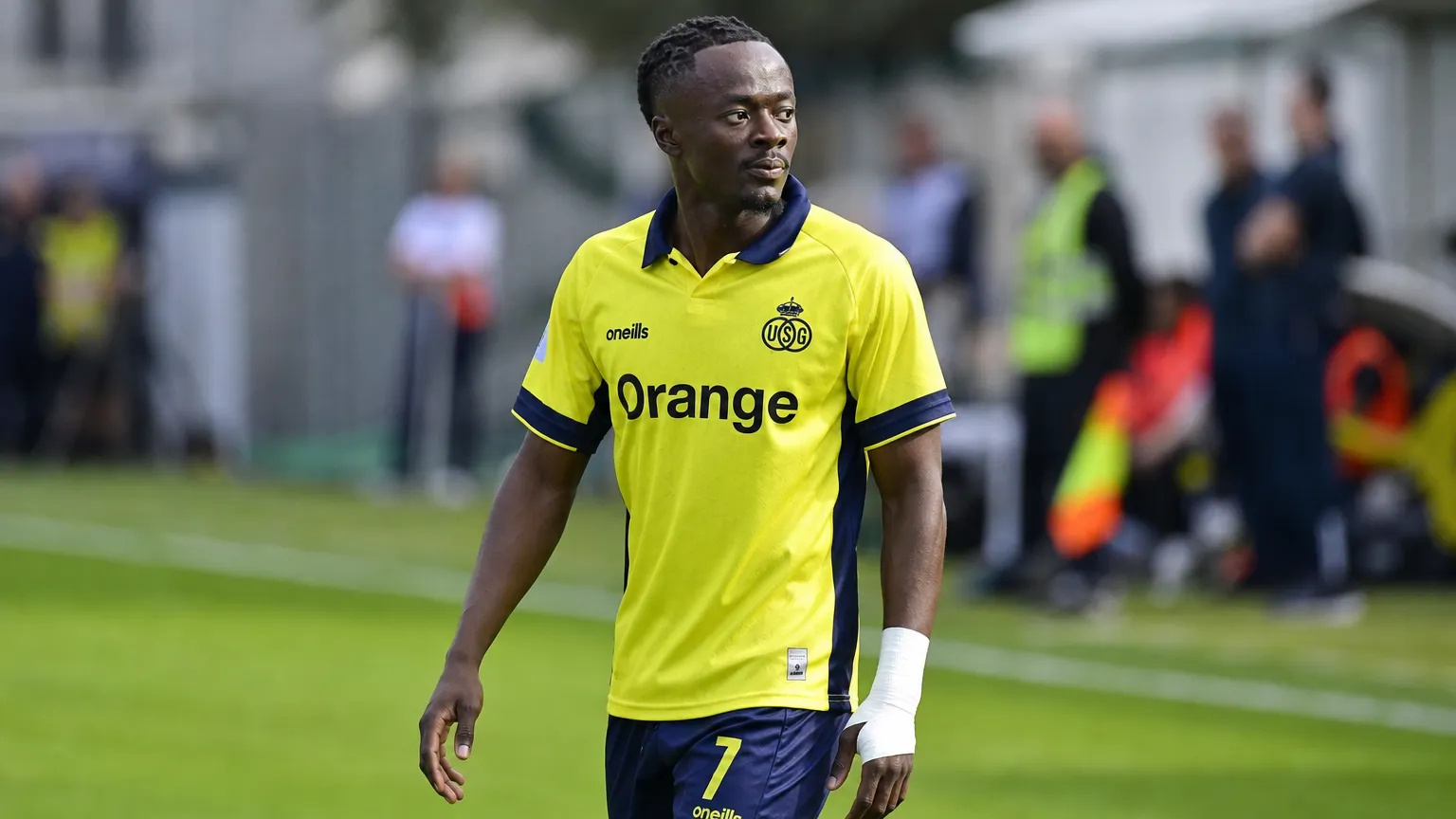 Mohammed Fuseini van Union op de rand van het veld in een geel shirt.