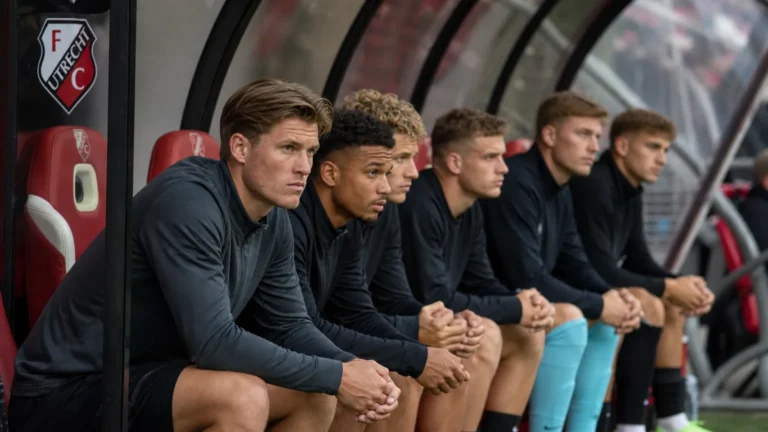 Invallers van FC Utrecht volgen aandachtig een wedstrijd vanuit de dug-out.