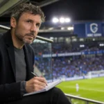 Mark van Bommel volgt als bondscoach aandachtig een wedstrijd vanuit de tribune van de Cegeka Arena.