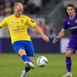 Christian Brüls speelt een pass in een duel op het middenveld.