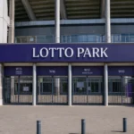 De ingang van het Lotto Park met een discreet RSC Anderlecht-clubanker.