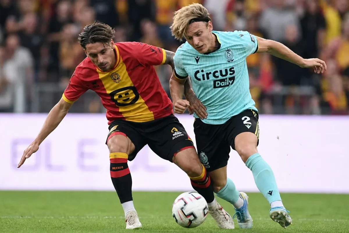 Twee voetballers van KV Mechelen en Standard in een luchtduel om de bal.