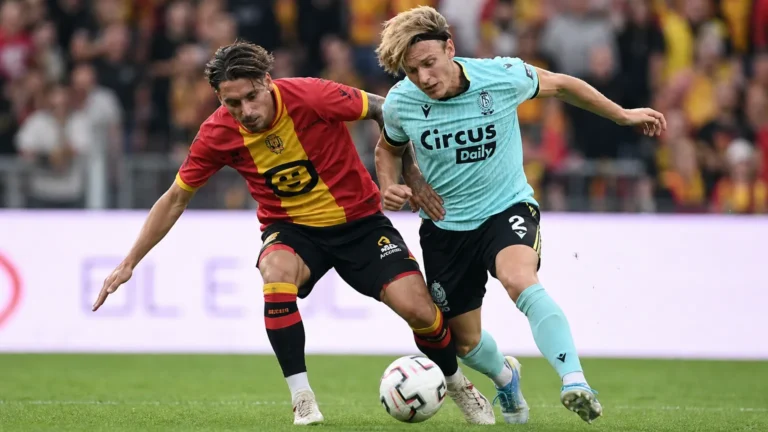 Twee voetballers van KV Mechelen en Standard in een luchtduel om de bal.