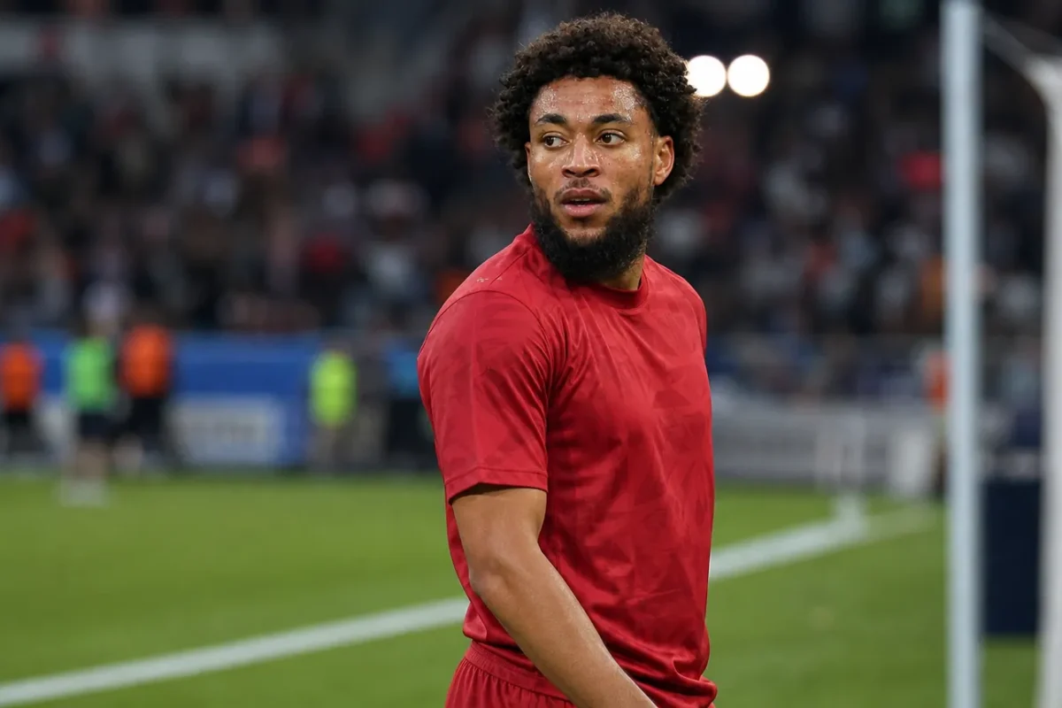 Arnaut Danjuma in een rood voetbalshirt aan de rand van het veld.