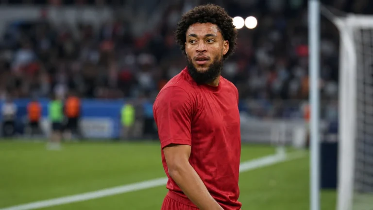 Arnaut Danjuma in een rood voetbalshirt aan de rand van het veld.