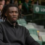 Don-Angelo Konadu kijkt aandachtig naar het veld vanaf de tribune van Lommel SK.