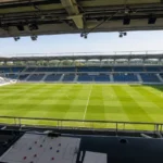 Leeg voetbalveld gezien vanuit een overdekte perstribune.
