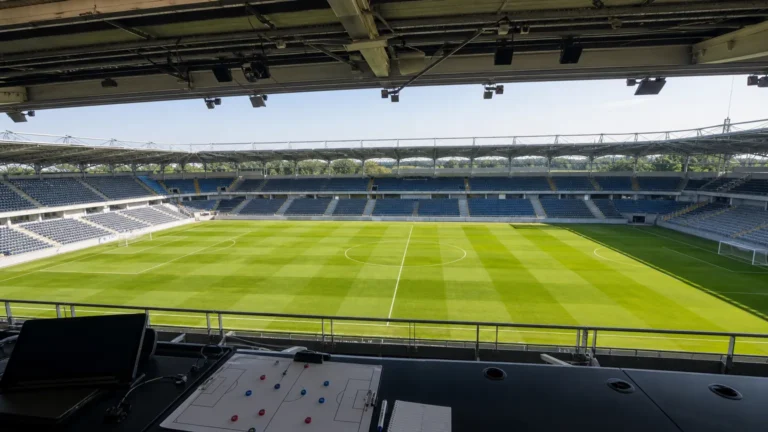 Leeg voetbalveld gezien vanuit een overdekte perstribune.