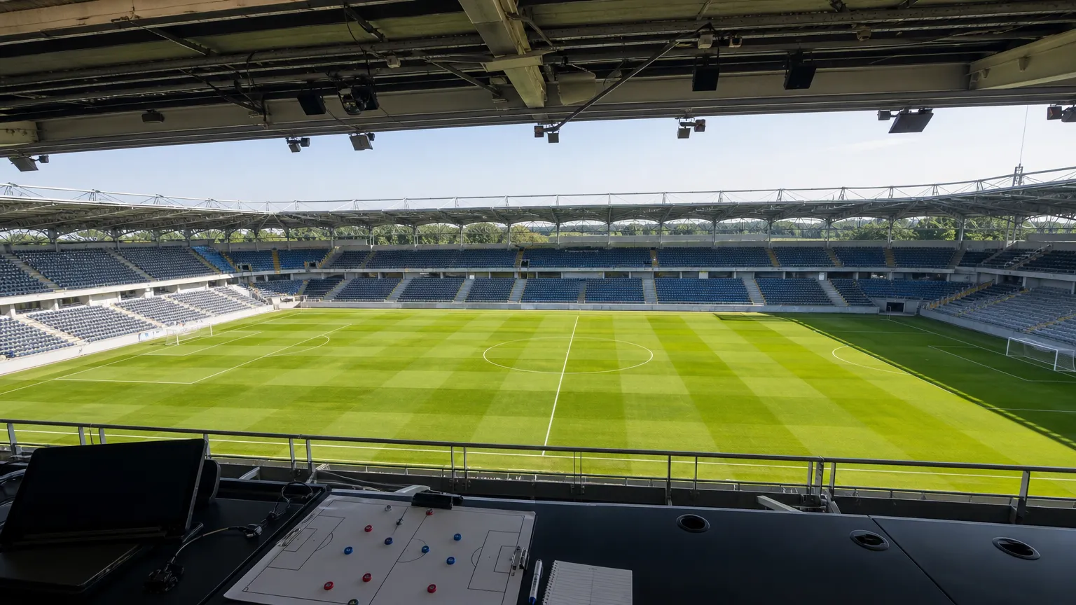Leeg voetbalveld gezien vanuit een overdekte perstribune.
