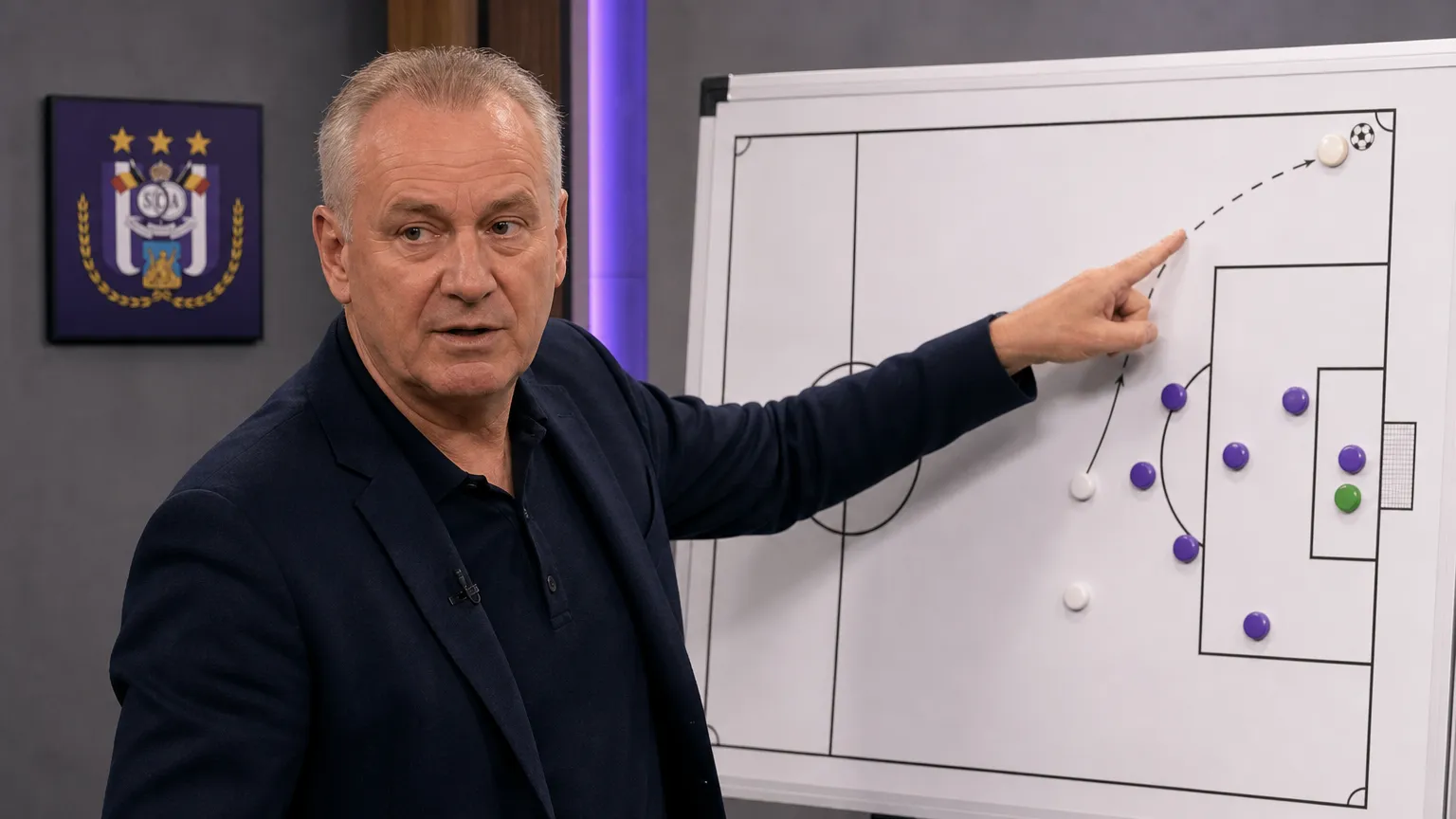 Marc Degryse bespreekt een hoekschopsituatie aan een analysetafel met een discreet RSC Anderlecht-embleem.