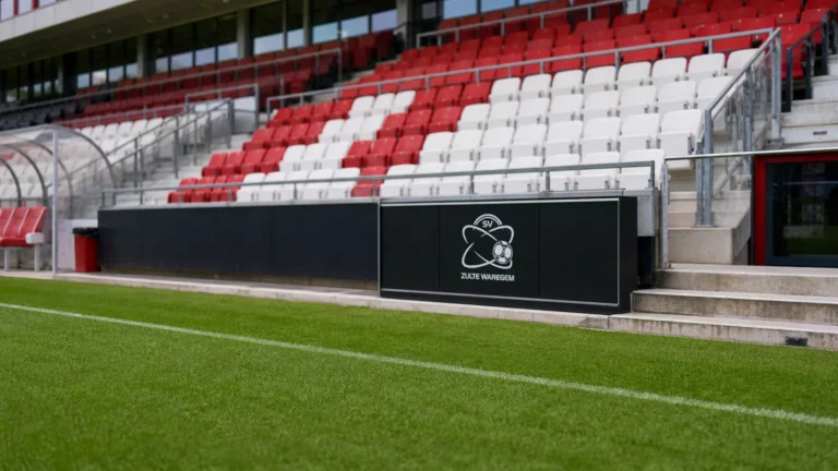 Zicht op de pitchside-zone van de Elindus Arena met een discreet logo van Zulte Waregem.