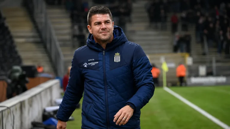 Mario Kohnen in een donkerblauwe coachjas langs de zijlijn na afloop van een wedstrijd.