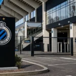 De ingang van een stadion met een discreet Club Brugge-clubanker.