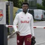 Toegang tot het trainingscomplex van Red Bull Salzburg met medewerkers op de achtergrond.