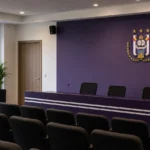 Een RSC Anderlecht-clubruimte met een discreet clubembleem aan de wand.