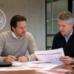 Medewerkers bespreken dossiers in een vergaderruimte van Ajax.