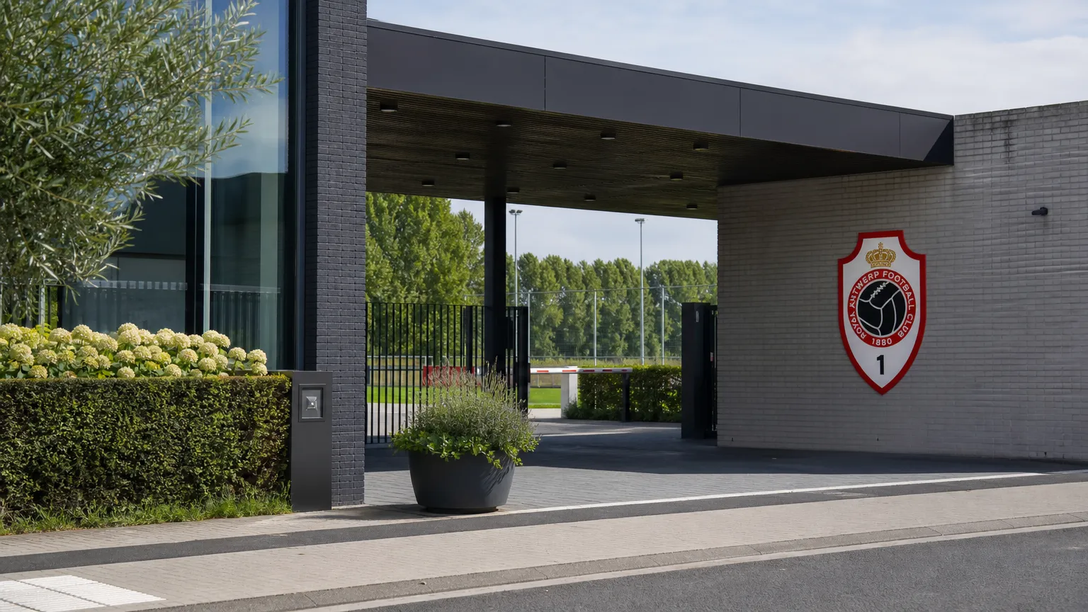 Ingang van het clubcomplex van Royal Antwerp FC met een discreet clubembleem aan de gevel.