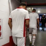 Anonieme spelers van Antwerp verlaten de spelerstunnel van een Engels stadion.