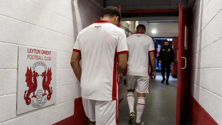 Anonieme spelers van Antwerp verlaten de spelerstunnel van een Engels stadion.