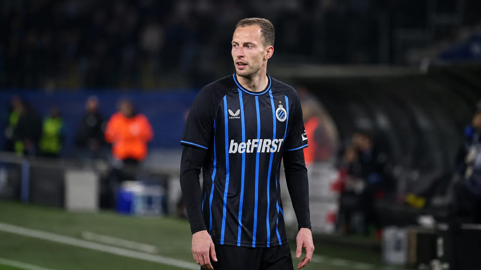 Gustaf Nilsson in het shirt van Club Brugge langs een voetbalveld.