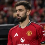 Bruno Fernandes in het tenue van Manchester United aan de rand van het veld.