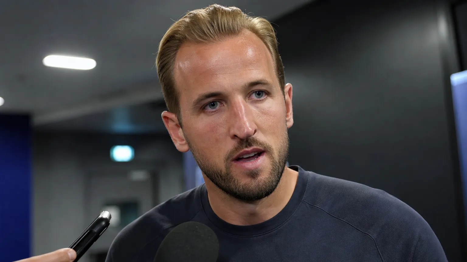 Harry Kane geeft een antwoord tijdens een persmoment in een neutrale stadionomgeving.