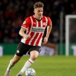 Matteo Dams in een rood-wit gestreept PSV-shirt tijdens een voetbalmoment.