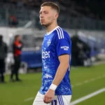 Ignace Van der Brempt in blauwe Como-kleding tijdens een rustig moment langs het veld.