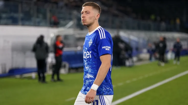 Ignace Van der Brempt in blauwe Como-kleding tijdens een rustig moment langs het veld.