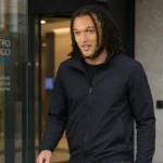 Diego Moreira in een neutrale sportjas bij de ingang van een medische kliniek in Milaan.