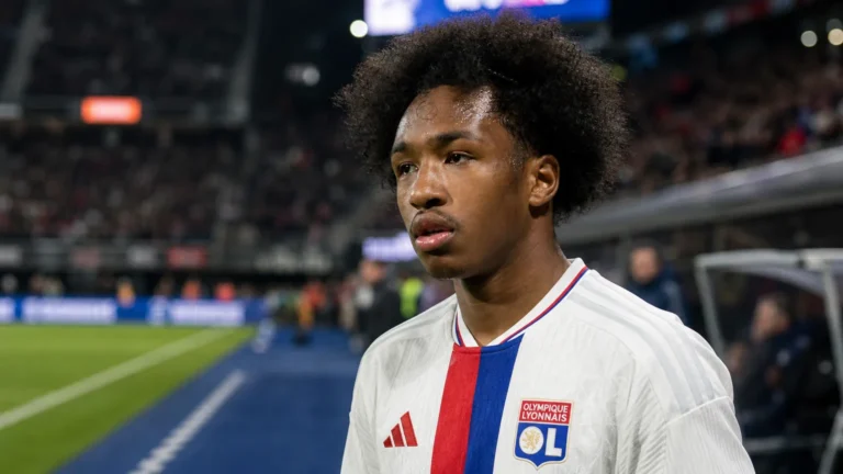 Malick Fofana in een witte spelersshirt in een stadionomgeving.