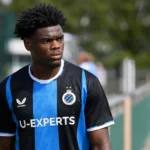 Vince Osuji in het blauw-zwarte shirt van Club Brugge langs de zijlijn.