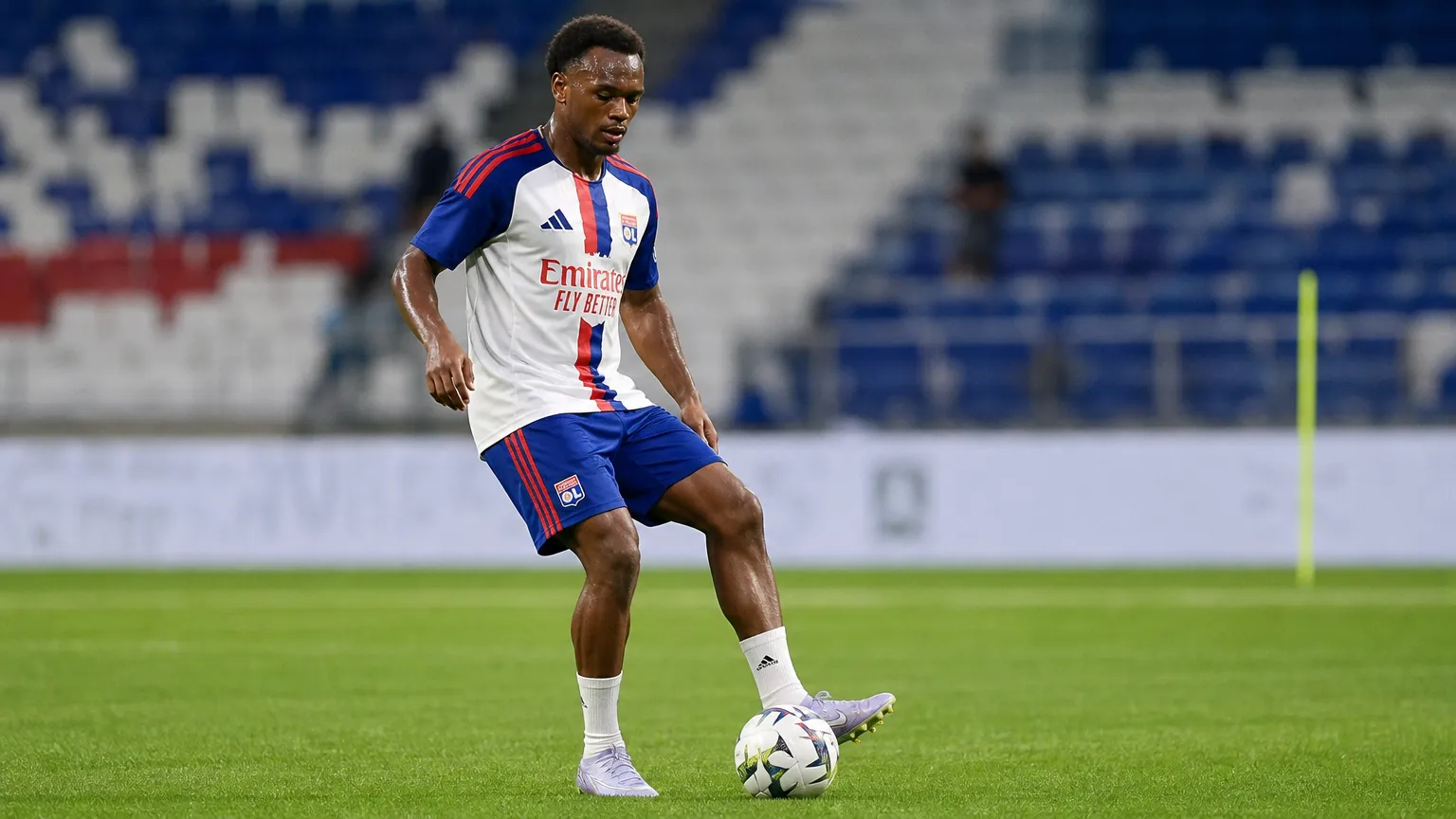 Loïs Openda warmt op in het tenue van Olympique Lyon op het veld.