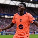Jesse Bisiwu viert een doelpunt op het veld in zijn oranje Barcelona-shirt.