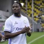 Promise David in het witte tenue van Union op een voetbalveld.