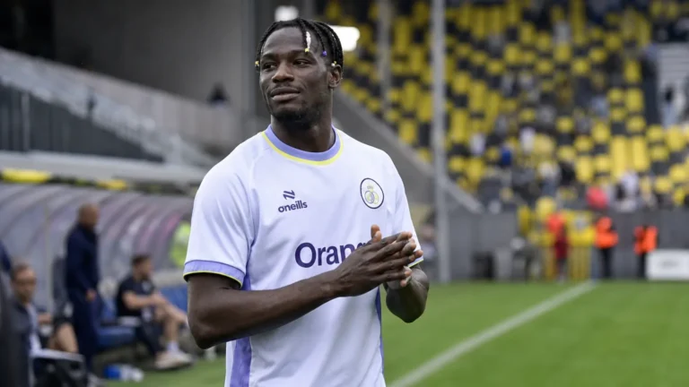 Promise David in het witte tenue van Union op een voetbalveld.