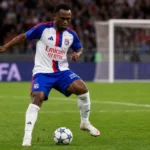Een speler van Olympique Lyon controleert de bal tijdens een wedstrijd in een vol stadion.