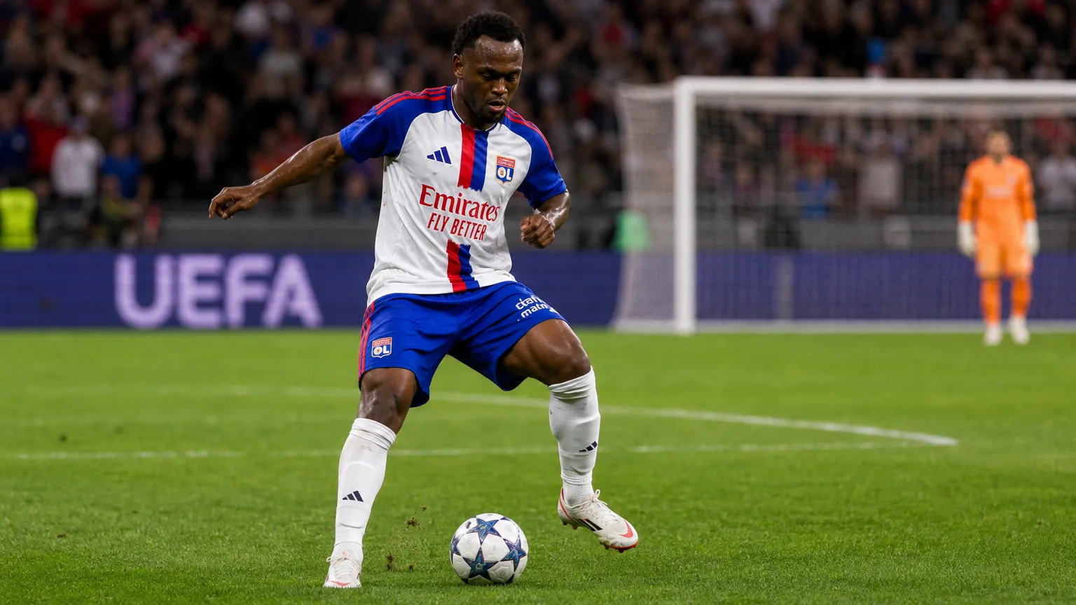 Een speler van Olympique Lyon controleert de bal tijdens een wedstrijd in een vol stadion.