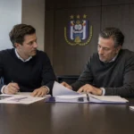 Medewerkers overleggen in een kantoorruimte van RSC Anderlecht tijdens transferplanning.