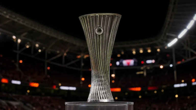 De Europa League-trofee staat centraal voor een wazige stadionachtergrond.