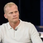 Karel Geraerts tijdens een televisie-interview in neutrale kleding.