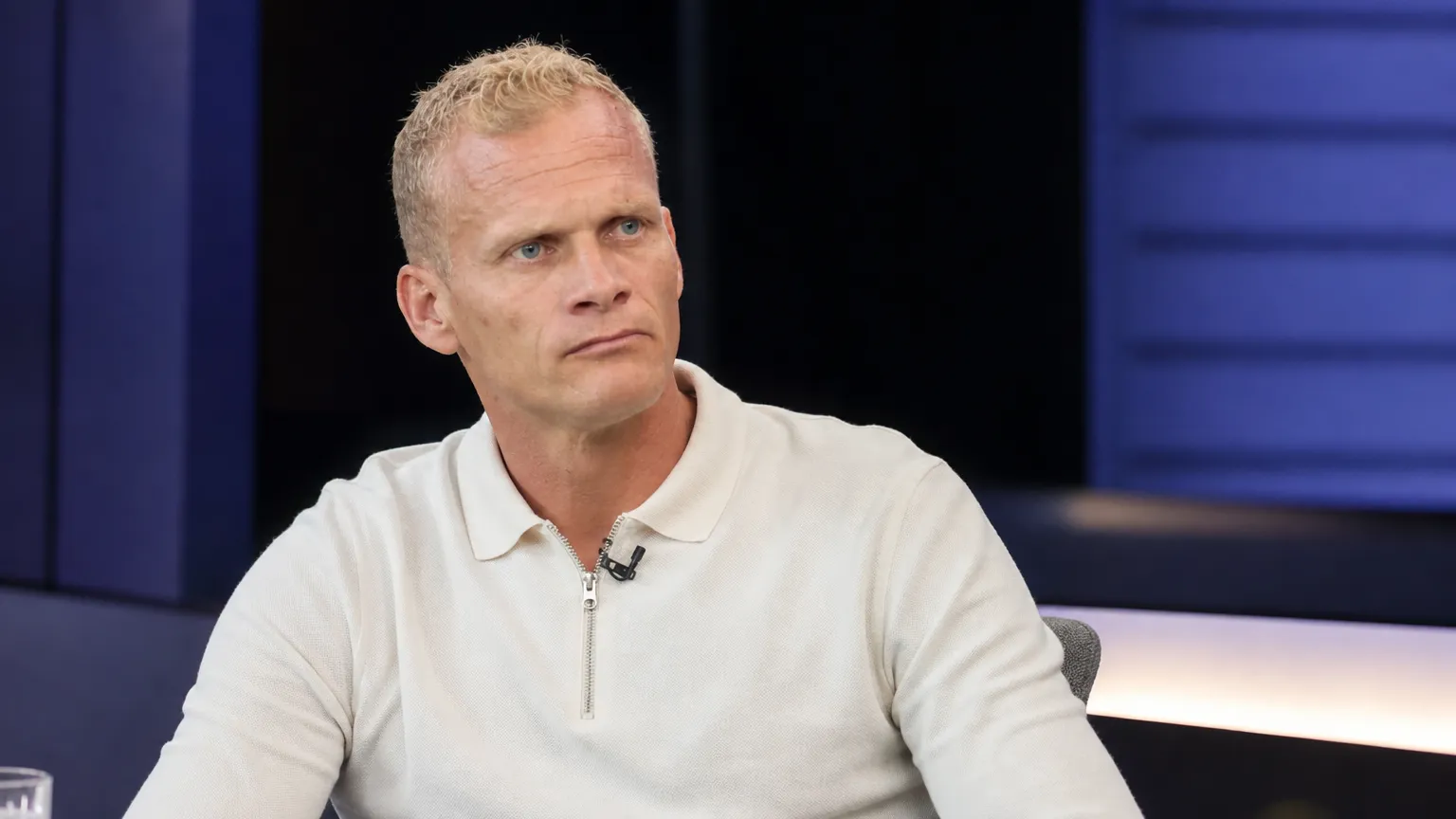 Karel Geraerts tijdens een televisie-interview in neutrale kleding.