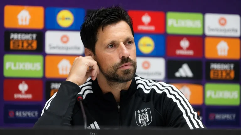 Een niet-spelende medewerker van RSC Anderlecht tijdens een persmoment voor een sponsorwand.
