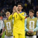 Thibaut Courtois applaudisseert in geel doelmanstenue na een interland van België.