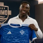 Moise Kean poseert tijdens zijn officiële voorstelling bij Como.