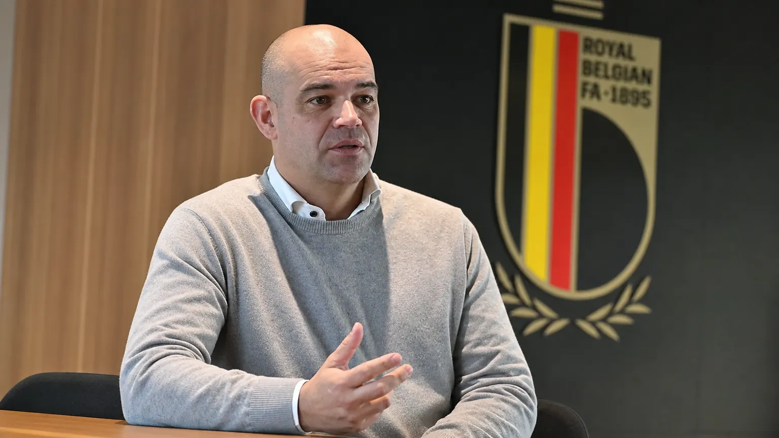 Peter Willems in een federatiekantoor voor een zichtbaar KBVB-schild.