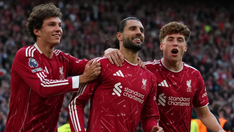 Drie Liverpool-spelers vieren op het veld na een wedstrijd.