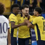 Ilan Hurtevent viert een doelpunt met ploegmaats van Union in gele shirts.
