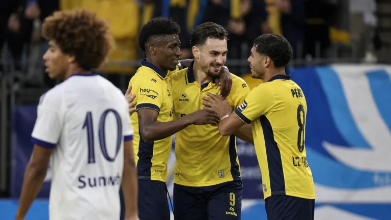 Ilan Hurtevent viert een doelpunt met ploegmaats van Union in gele shirts.